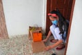 Food delivery and shopping during coronavirus pandemic. Girl holds cardboard boxes in gloves and medical mask