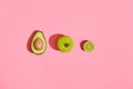 Food design. Composition of fresh fruits, avocado green apple and half of cutted avocado on pink coral background Royalty Free Stock Photo