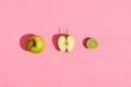 Food design. Composition of fresh fruits, green apple, half of green apple and lime on pink coral background Royalty Free Stock Photo