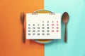 Food diary or food daily calendar, dish spoon and fork on the color table background