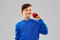 Smiling boy in blue hoodie with red apple Royalty Free Stock Photo