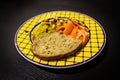 Food Dish on Black Wooden Background. Couscous, Tomato, Peanuts, Raisins, Bread. Yellow Blue Plate. Close-Up