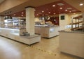 Food distribution line in a public place with plates and fruit on the floor restrictive markings to maintain distance