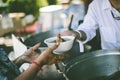 Food donation to help people in hunger relief : hands of the poor receive food from the donor`s share Royalty Free Stock Photo