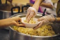 Food donation to the poor: The hands of the homeless are waiting to receive food from volunteers