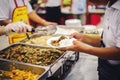 Food donation to the poor: The hands of the homeless are waiting to receive food from volunteers