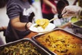 Food donation to the poor: The hands of the homeless are waiting to receive food from volunteers