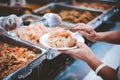 Food donation to the poor : The hands of the homeless are waiting to receive food from volunteers