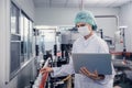 Food and drink industry staff worker working at conveyor belt production line machine in beverage factory with clean and hygiene Royalty Free Stock Photo