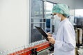 Food and drink industry staff worker working at conveyor belt production line machine in beverage factory with clean and hygiene Royalty Free Stock Photo