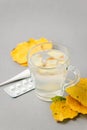 Food and drink, still life health care concept. Ginger tea infusion beverage in glass cup, yellow leaves, thermometer, pills on Royalty Free Stock Photo