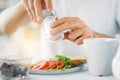 Close up of male hands seasoning food by salt mill Royalty Free Stock Photo