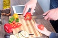 Food, family, cooking and people concept - girl giving tomato to the father. Man chopping paprika. Royalty Free Stock Photo