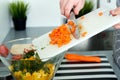 Food, family, cooking and people concept - Man chopping a carrot on cutting board with knife in kitchen Royalty Free Stock Photo