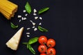 Food frame. Pasta ingredients. Cherry-tomatoes, spaghetti pasta, garlic, basil, parmesan and spices on dark background, copy Royalty Free Stock Photo