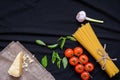 Food frame. Pasta ingredients. Cherry-tomatoes, spaghetti pasta, garlic, basil, parmesan and spices on dark background, copy Royalty Free Stock Photo