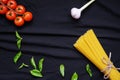 Food frame. Pasta ingredients. Cherry-tomatoes, spaghetti pasta, garlic, basil, parmesan and spices on dark background, copy Royalty Free Stock Photo