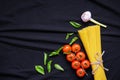 Food frame. Pasta ingredients. Cherry-tomatoes, spaghetti pasta, garlic, basil, parmesan and spices on dark background, copy Royalty Free Stock Photo