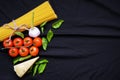 Food frame. Pasta ingredients. Cherry-tomatoes, spaghetti pasta, garlic, basil, parmesan and spices on dark background, copy Royalty Free Stock Photo