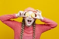 Food and Fruit Series. Winsome Girl In Coral Knitted Clothing Posing With Yellow Lemon Slices In Front of Eyes as Demonstration of