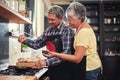 Food, happy senior couple cooking in kitchen and at their home. Collaboration or teamwork of partners, family or