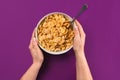 Food, healthy eating, people and diet concept - close up of woman eating muesli for breakfast over purple background Royalty Free Stock Photo