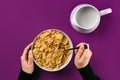 Food, healthy eating, people and diet concept - close up of woman eating muesli with milk for breakfast over purple Royalty Free Stock Photo