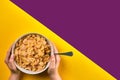 Food, healthy eating, people and diet concept - close up of woman eating muesli for breakfast over purple and yellow Royalty Free Stock Photo