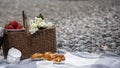 Food, holidays and celebration concept - close picnic basket with thermos with tea, rolls, strawberries, flowers on the beach