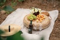 Food, holidays and celebration concept - close up of picnic basket champagne bottle and french roll bread on summer beach