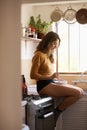 Food, home and breakfast for woman in kitchen with bowl for cereal and relax by stove and window on counter. Young Royalty Free Stock Photo