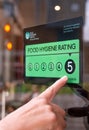 Food hygiene rating sticker with a persons hand pointing. Royalty Free Stock Photo