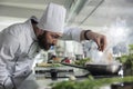 Food industry worker preparing ingredients for evening meal in professional kitchen. Royalty Free Stock Photo