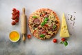 Food ingredients for italian pizza, cherry tomatoes, flour, cheese, basil, rolling pin, spices on light grey background