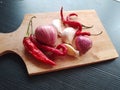 Food ingredients, onion, chili pepper, garlic on wooden chutting board Royalty Free Stock Photo