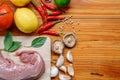 Food ingredients on wooden table in kitchen, meat on cutting board Royalty Free Stock Photo