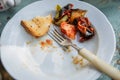 Food leftovers on the plate. Vegetables, meat and bread