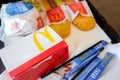 Food at McDonald`s. A set of breakfast products on a tray. Dranik, one-pink sugar packets, burger, napkins, straws