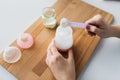 Hands with bottle and scoop making formula milk Royalty Free Stock Photo