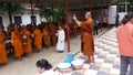 Food offerings to a monk while the monk take photo