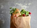 Food in a paper bag. Food donation or food delivery concept. Free space for text. Oil, bread, cabbage, salad, vegetables Royalty Free Stock Photo