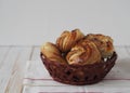 Food pastry background.Homemade buns in a natural basket on a white wooden background