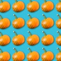 Food pattern with arrangement of orange pumpkins on turquoise background