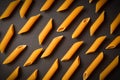 Food pattern of Raw Italian penne pasta pieces scattered on dark background Royalty Free Stock Photo