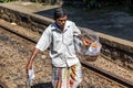 Food peddler carries sweets in a wicker basket at a railway station