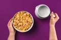 Food and people concept - hands of woman eating cereals corn flakes for breakfast and pouring milk Royalty Free Stock Photo