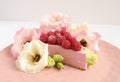 Cheesecake with raspberries and fresh flowers on a plate