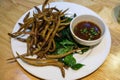 Food Photo of Deep Fried White-spotted Conger Fish on Basil Leaves with Dipping Sauce in a Restaurant