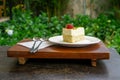 Food Photo of Piece of Cheese Cake with Strawberry and Pistachio on a Wooden Tray with Heart Shaped Spoons and Napkin Royalty Free Stock Photo