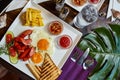 Food photography composition aesthetic. Breakfast meal on a white plate - fried eggs, chips, toasts, fried sausages and vegetables